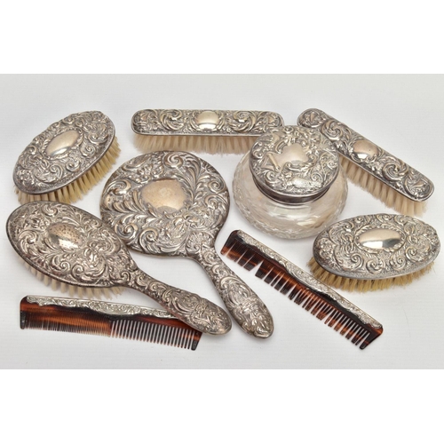 90 - A SILVER VANITY SET, comprising nine items to include a mirror, a molded glass powder bottle, a hair... 