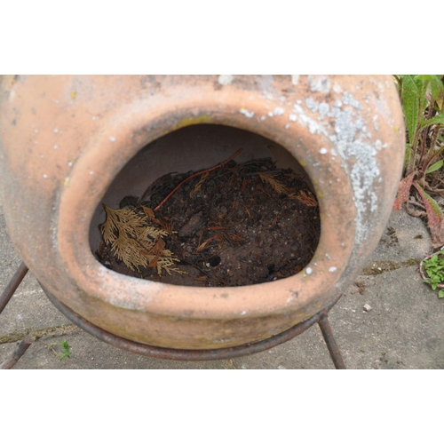 1204 - A LARGE TERRACOTTA CHIMINEA, with a later lid, on a wrought iron stand, overall height 103cm