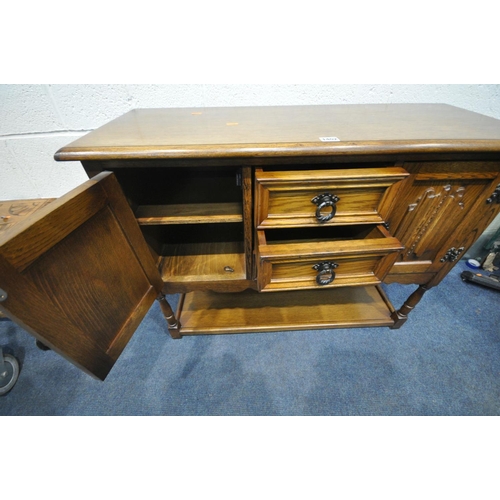 1402 - AN OAK LINENFOLD TWO DOOR CABINET, with three central drawers, on turned legs united by an undershel... 