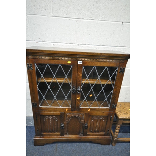 1403 - A LATE 20TH CENTURY OAK TWO DOOR LEAD GLAZED CABINET, with two bottom linenfold cupboard doors, widt... 