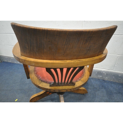 1414 - AN EARLY 2OTH CENTURY OAK SWIVEL OFFICE CHAIR, with red leather upholstered seat, on four legs, labe... 