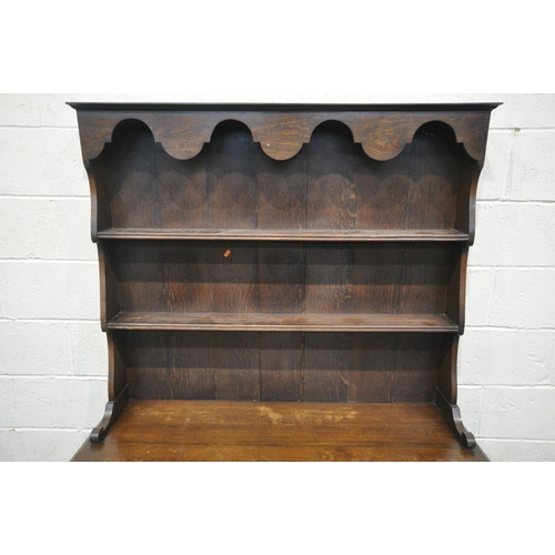 1449 - AN EARLY 20TH CENTURY OAK DRESSER with a two tier plate rack and two drawers, on turned front legs u... 