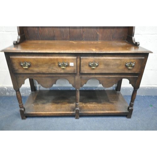 1449 - AN EARLY 20TH CENTURY OAK DRESSER with a two tier plate rack and two drawers, on turned front legs u... 