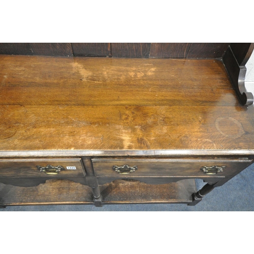 1449 - AN EARLY 20TH CENTURY OAK DRESSER with a two tier plate rack and two drawers, on turned front legs u... 