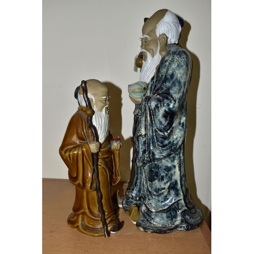 442 - TWO CHINESE CERAMIC FIGURES, each holding a stick and a fruit, late twentieth century/contemporary, ... 