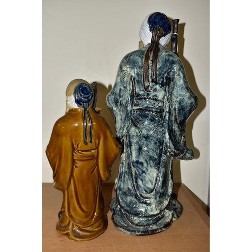 442 - TWO CHINESE CERAMIC FIGURES, each holding a stick and a fruit, late twentieth century/contemporary, ... 