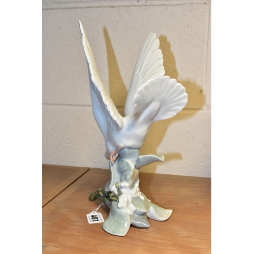 481 - A LLADRO TURTLE DOVE, model no 4550, perched on leaves with wings raised, designed by Fulgencio Garc... 