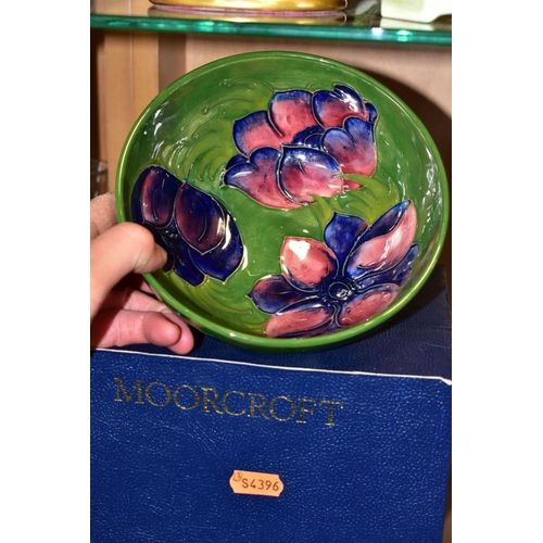 517 - A BOXED MOORCROFT ANENOME BOWL, with tubelined pink and purple anemones on a green/blue ground, diam... 