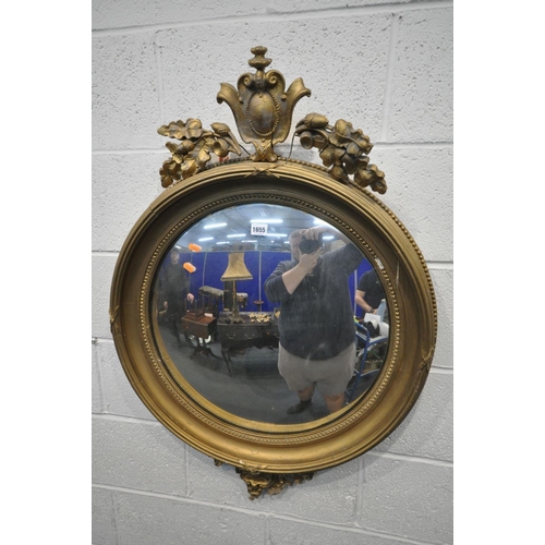 1655 - A REGENCY GILTWOOD CONVEX WALL MIRROR, the surmount with Lobed leaves and acorns surrounding a scrol... 