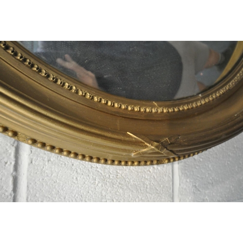 1655 - A REGENCY GILTWOOD CONVEX WALL MIRROR, the surmount with Lobed leaves and acorns surrounding a scrol... 