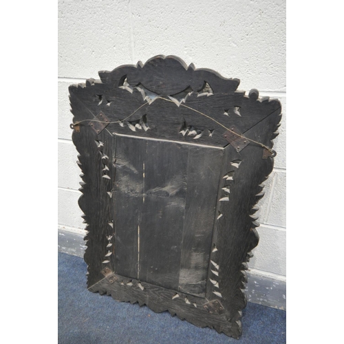 1658 - A 19TH CENTURY EBONISED CARVED OAK WALL MIRROR, with lions mask and foliate decoration, and bevelled... 