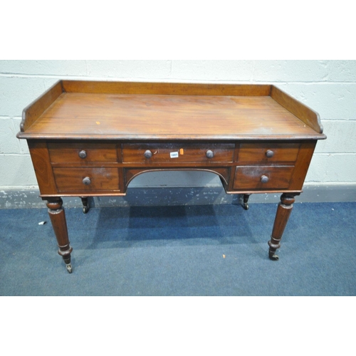 1665 - A VICTORIAN MAHOGANY DESK, with a gallery back and sides, five assorted drawers, on turned legs and ... 