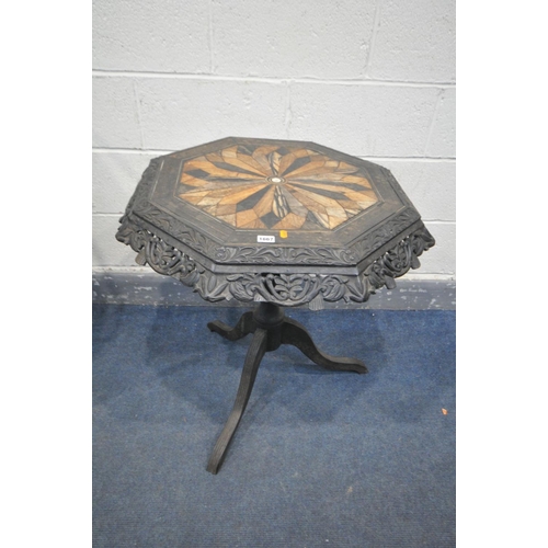 1667 - A 19TH CENTURY EBONISED CARVED WOOD OCTAGONAL TRIPOD OCCASIONAL TABLE, the top with a multi wood par... 