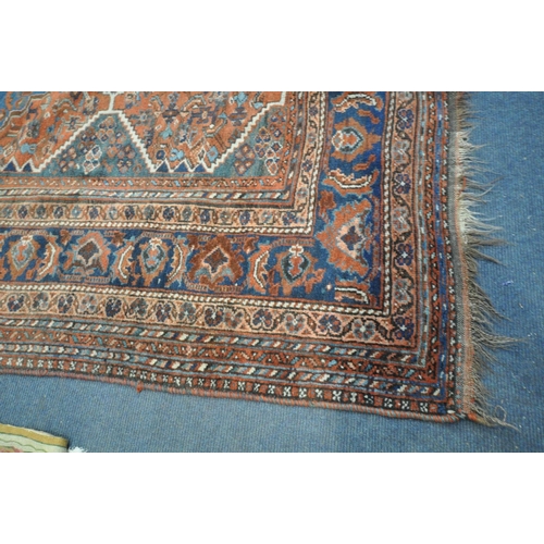 1669 - A 19TH CENTURY MIDDLE EASTERN HAND WOVEN RED HERIZ RUG, 160cm x 210cm, and a gold foliate rug (2)