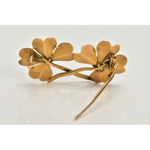 16 - A YELLOW METAL BROOCH, designed as a double four leaf clover, stamped to the reverse 15ct, fitted wi... 