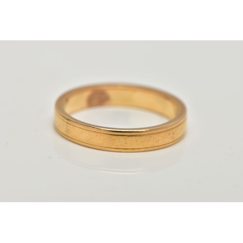 18 - A YELLOW METAL BAND RING, worn engraved detail all round, ring size M leading edge, unmarked, approx... 