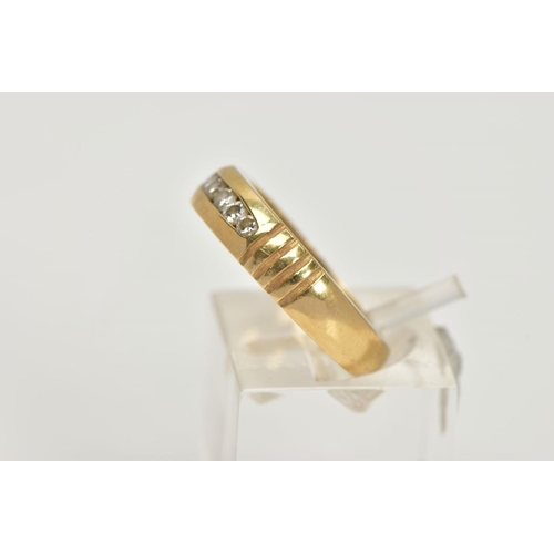 32 - A YELLOW METAL DIAMOND RING, wide band measuring approximately 4.7mm, designed with a row of channel... 