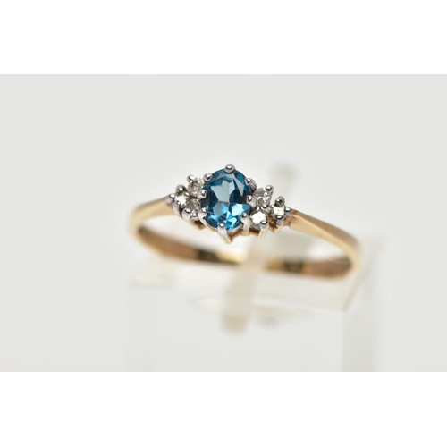 56 - A 9CT YELLOW GOLD TOPAZ AND DIAMOND DRESS RING, set with a principal oval cut blue topaz, flanked to... 