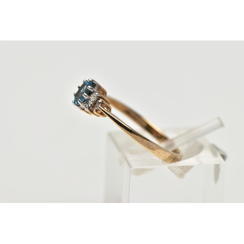 56 - A 9CT YELLOW GOLD TOPAZ AND DIAMOND DRESS RING, set with a principal oval cut blue topaz, flanked to... 