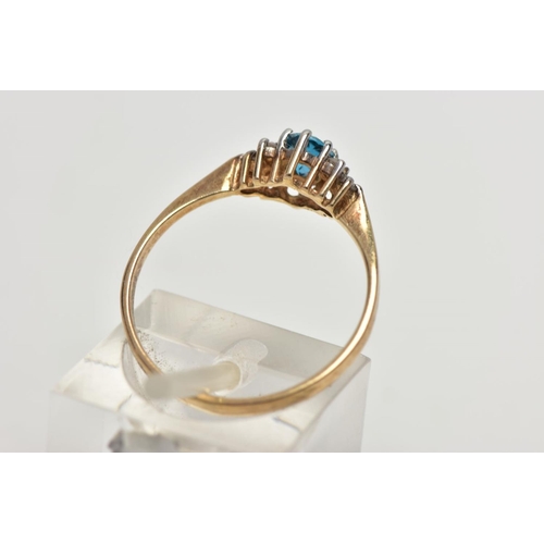 56 - A 9CT YELLOW GOLD TOPAZ AND DIAMOND DRESS RING, set with a principal oval cut blue topaz, flanked to... 