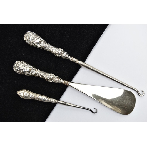 65 - TWO SILVER HANDLED BUTTON HOOKS AND A SILVER HANDLED SHOE HORN, a button hook and shoe horn silver h... 