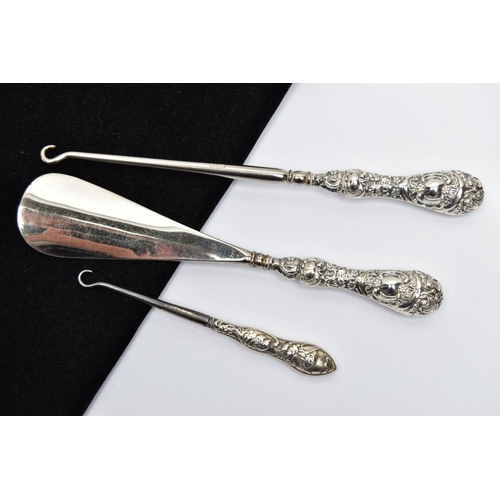 65 - TWO SILVER HANDLED BUTTON HOOKS AND A SILVER HANDLED SHOE HORN, a button hook and shoe horn silver h... 