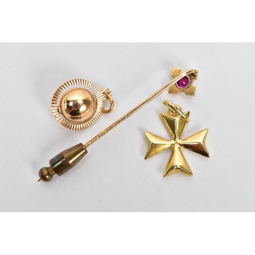 9 - TWO YELLOW METAL CHARMS AND A STICK PIN, to include a puffy Maltese cross charm fitted with an oval ... 