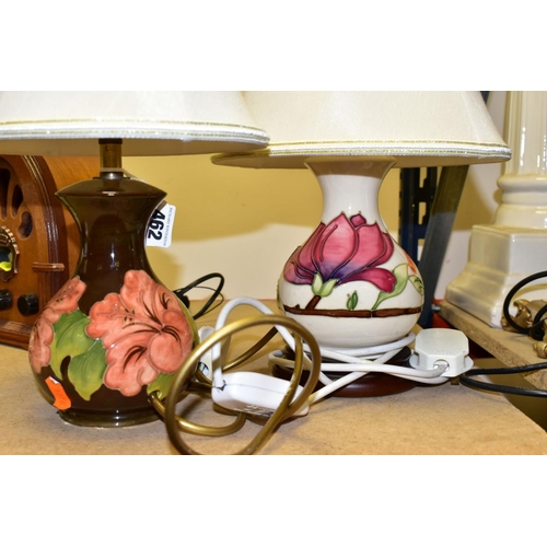 462 - TWO MOORCROFT POTTERY TABLE LAMPS WITH CREAM SHADES, comprising a coral 'Hibiscus' design on a dark ... 