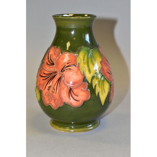 494 - A MOORCROFT POTTERY BALUSTER VASE DECORATED WITH CORAL HIBISCUS, on a green ground, impressed marks ... 