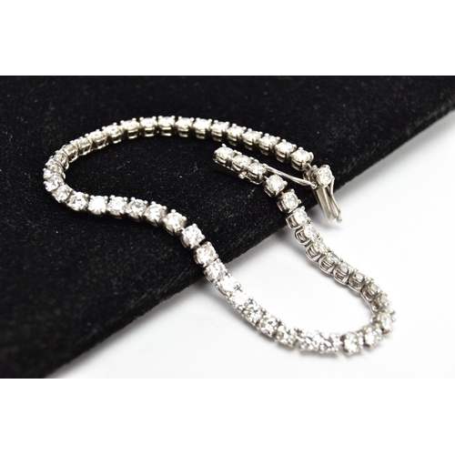 1 - A MODERN PLATINUM DIAMOND LINE BRACELET, set with fifty-two round brilliant cut diamonds, four claw ... 