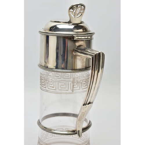 119 - A LATE VICTORIAN SILVER MOUNTED GLASS CLARET JUG, the hinged cover with foliate pierced thumbpiece, ... 