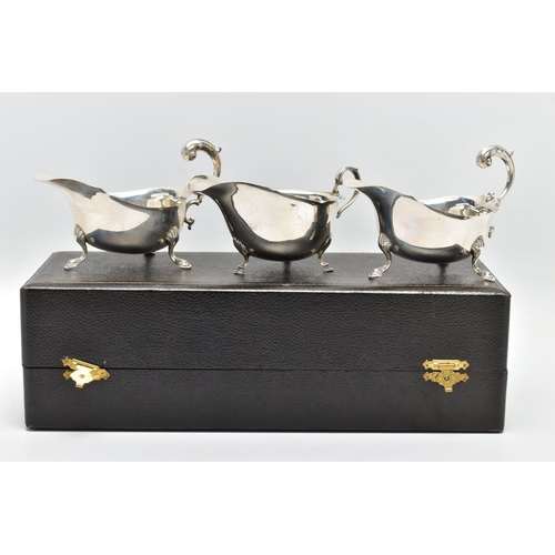 122 - A CASED PAIR OF GEORGE VI SILVER SAUCEBOATS, of oval form, S scroll handles, wavy rims, three cabrio... 