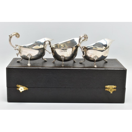 122 - A CASED PAIR OF GEORGE VI SILVER SAUCEBOATS, of oval form, S scroll handles, wavy rims, three cabrio... 