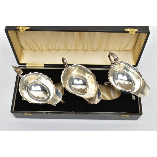 122 - A CASED PAIR OF GEORGE VI SILVER SAUCEBOATS, of oval form, S scroll handles, wavy rims, three cabrio... 