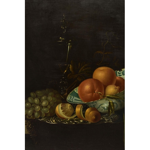 322 - A 20TH CENTURY STILL LIFE STUDY OF FRUIT AFTER WILLEM KALF, depicting oranges, lemons in a delft bow... 