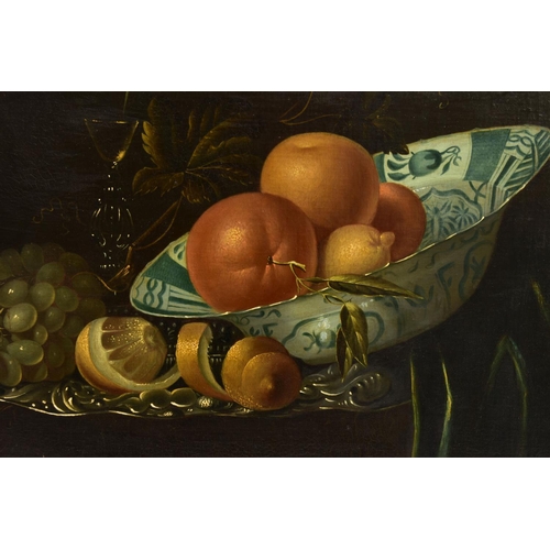 322 - A 20TH CENTURY STILL LIFE STUDY OF FRUIT AFTER WILLEM KALF, depicting oranges, lemons in a delft bow... 