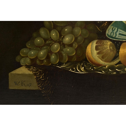 322 - A 20TH CENTURY STILL LIFE STUDY OF FRUIT AFTER WILLEM KALF, depicting oranges, lemons in a delft bow... 