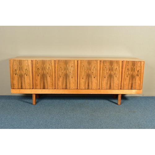 348 - GORDON RUSSELL (BRITISH 1892-1980) A 1960'S ROSEWOOD AND TEAK 7FT SIDEBOARD, the six doors with book... 