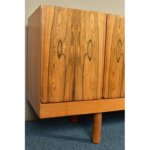 348 - GORDON RUSSELL (BRITISH 1892-1980) A 1960'S ROSEWOOD AND TEAK 7FT SIDEBOARD, the six doors with book... 