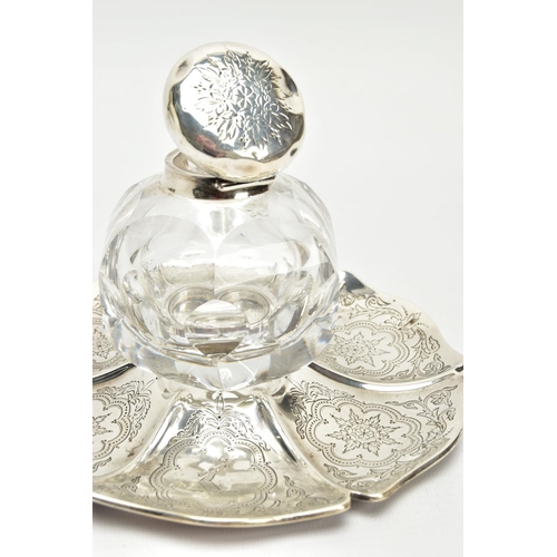 49 - A VICTORIAN SILVER AND GLASS INKWELL ON STAND, of wavy circular outline, foliate engraved decoration... 