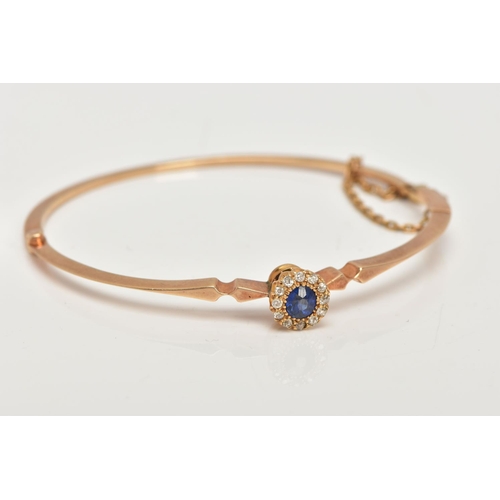 6 - AN EARLY TWENEITH CENTURY GOLD SAPPHIRE AND DIAMOND BANGLE, a yellow gold oval hinged bangle, set wi... 