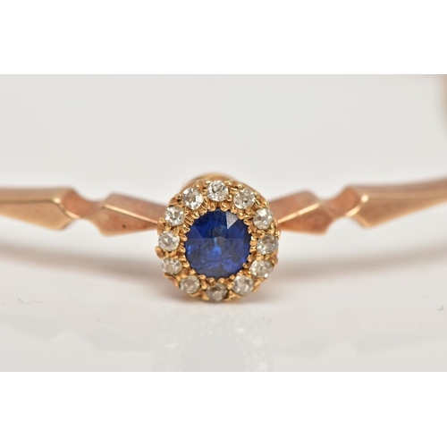 6 - AN EARLY TWENEITH CENTURY GOLD SAPPHIRE AND DIAMOND BANGLE, a yellow gold oval hinged bangle, set wi... 