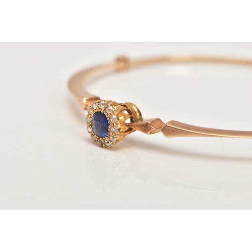 6 - AN EARLY TWENEITH CENTURY GOLD SAPPHIRE AND DIAMOND BANGLE, a yellow gold oval hinged bangle, set wi... 