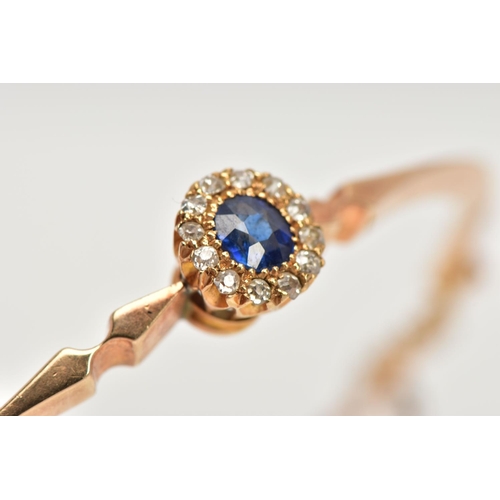 6 - AN EARLY TWENEITH CENTURY GOLD SAPPHIRE AND DIAMOND BANGLE, a yellow gold oval hinged bangle, set wi... 