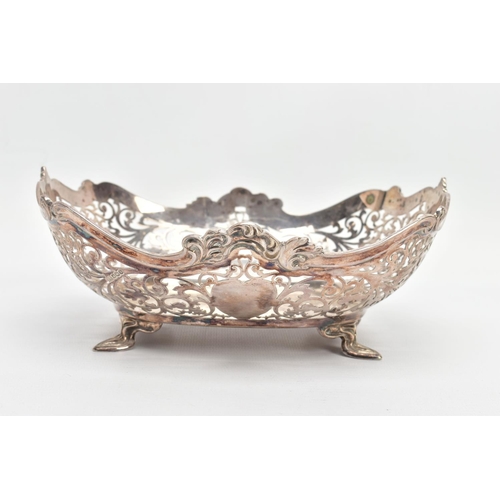 61 - A GEORGE V PIERCED SILVER DISH OF SHAPED RECTANGULAR FORM, wavy rim with cast scrolls above pierced ... 