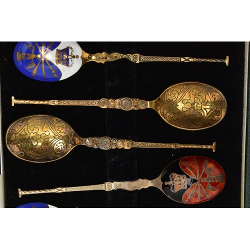 97 - A CASED SET OF SIX GEORGE V SILVER GILT AND HARLEQUIN ENAMEL COFFEE SPOONS, engine turned decoration... 