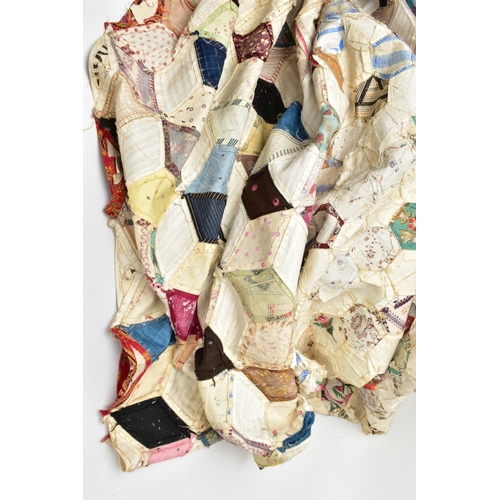 216 - A HAND STITCHED PATCHWORK QUILT, the geometric design incorporating fabrics which appear to be both ... 