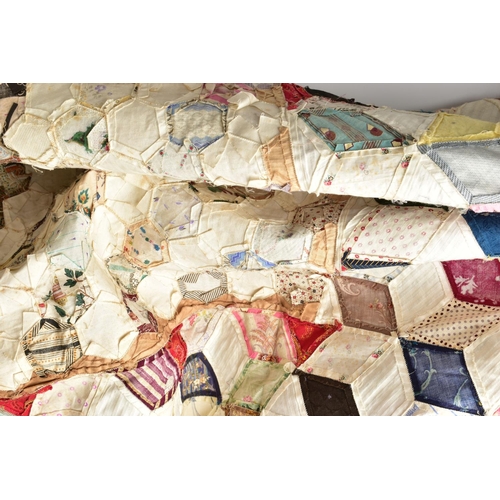 216 - A HAND STITCHED PATCHWORK QUILT, the geometric design incorporating fabrics which appear to be both ... 