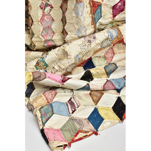 216 - A HAND STITCHED PATCHWORK QUILT, the geometric design incorporating fabrics which appear to be both ... 