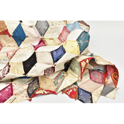 216 - A HAND STITCHED PATCHWORK QUILT, the geometric design incorporating fabrics which appear to be both ... 